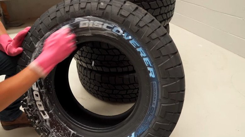 A close-up of a muddy tire showing subtle blue discoloration on the sidewall.