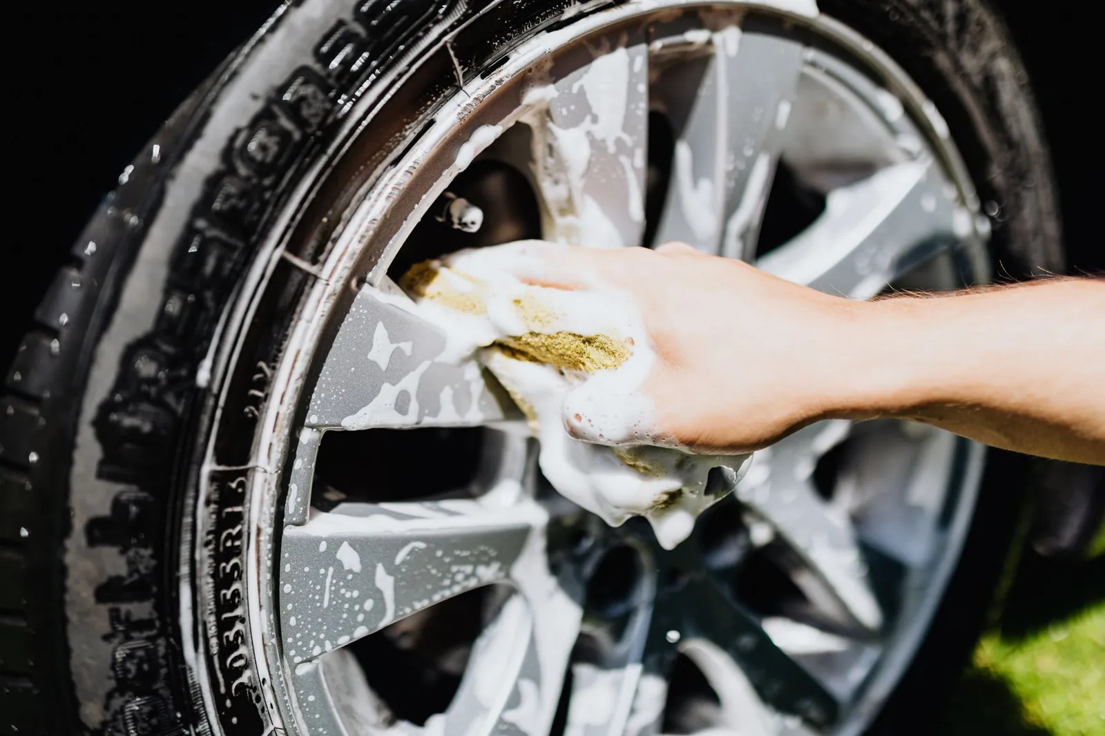 A mechanic inspects a tire for signs of uneven tread wear and cupping.