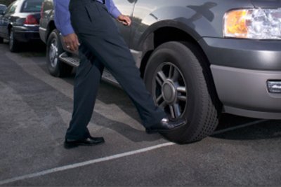 A professional salesperson evaluating a potential client in a bright modern car dealership.