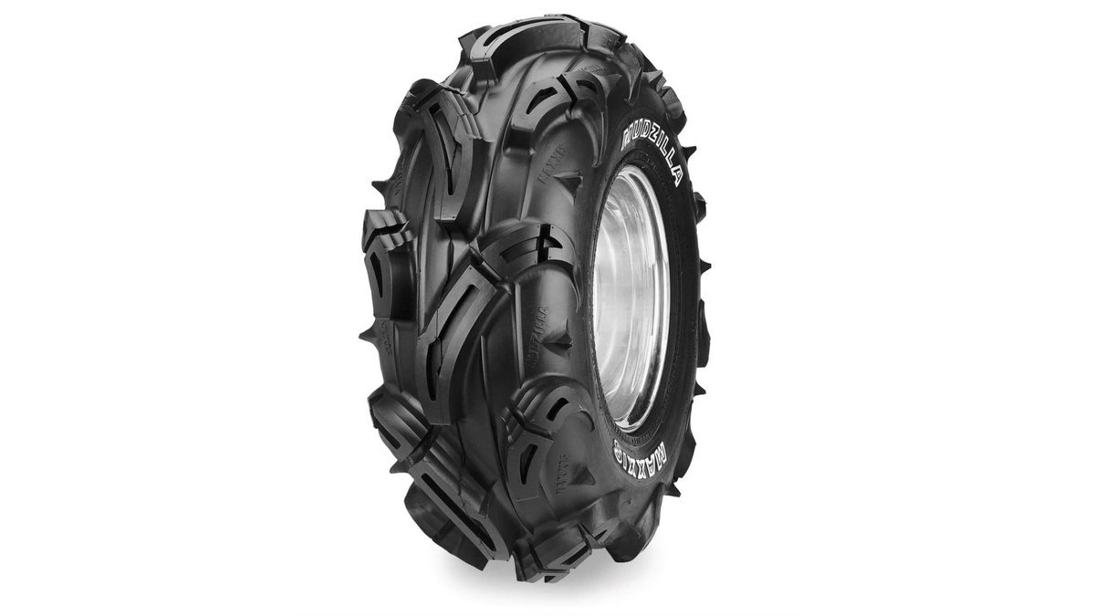 A rugged ATV parked on a muddy trail showcasing lightweight mud tires.
