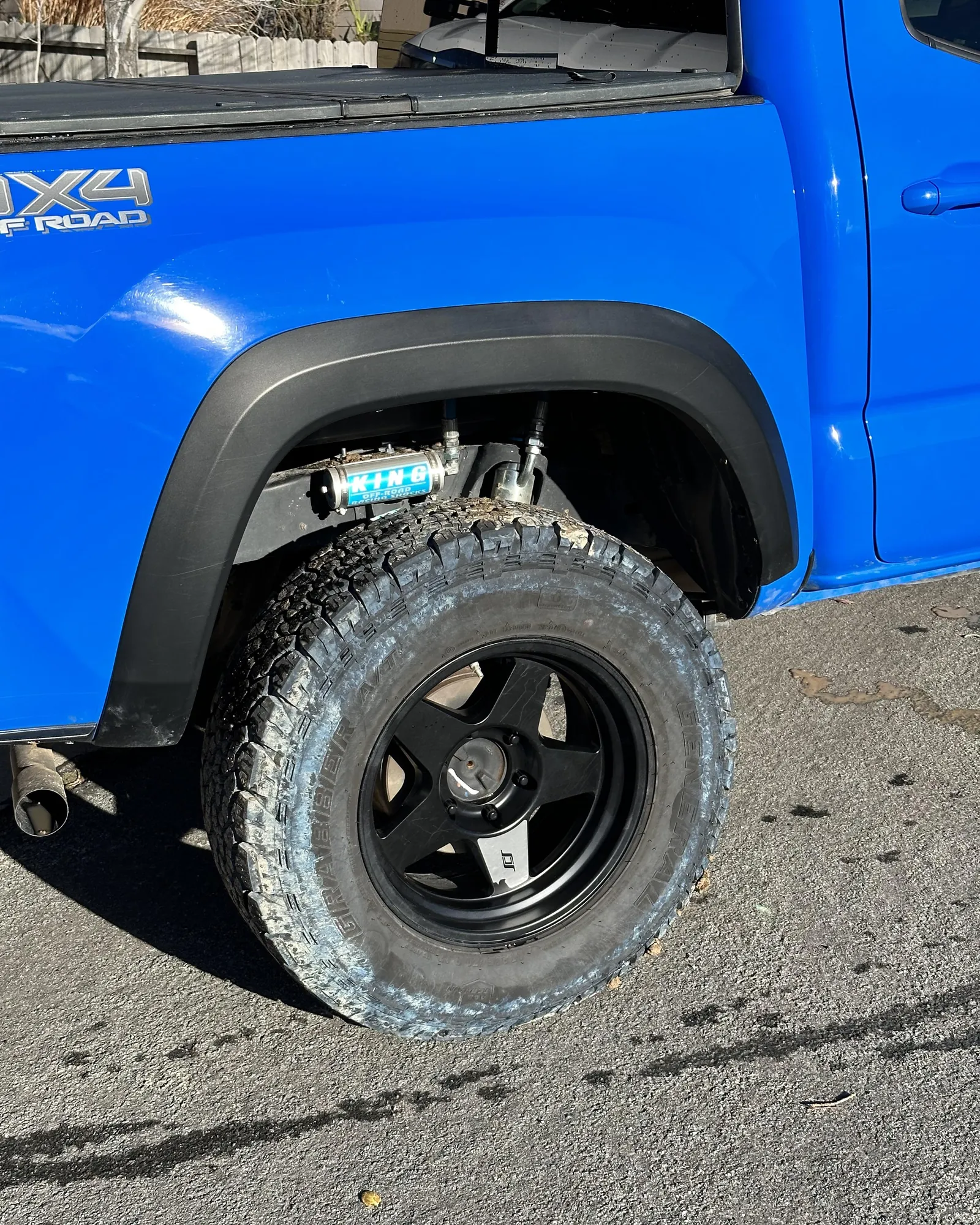 The sidewall of a car tire showing a faint blue haze from chemical migration.