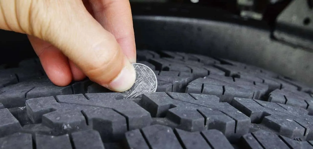 Using a penny to perform a quick visual inspection of car tire tread.